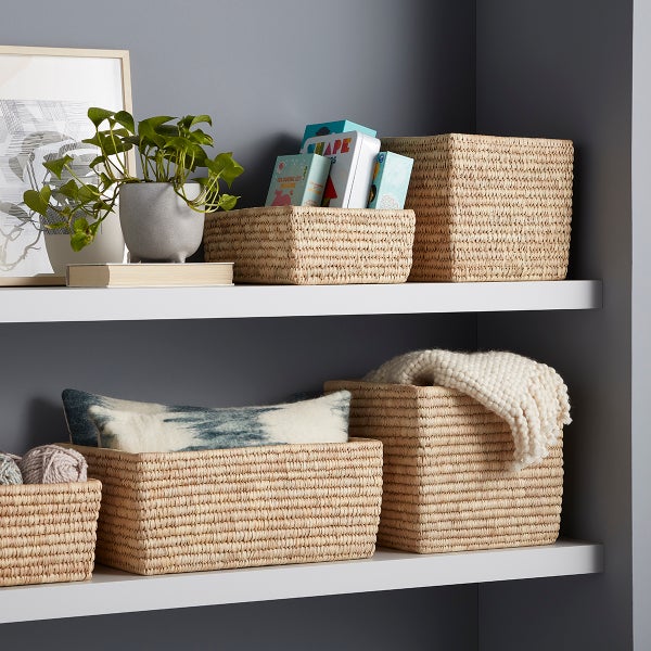 Five woven baskets on two shelves